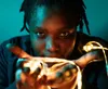 a woman with dreadlocks holding a glass