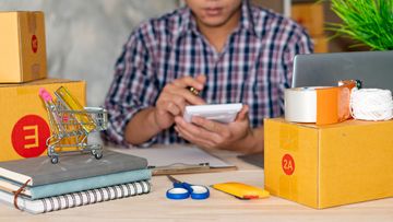 A man using a calculator checking his inventory