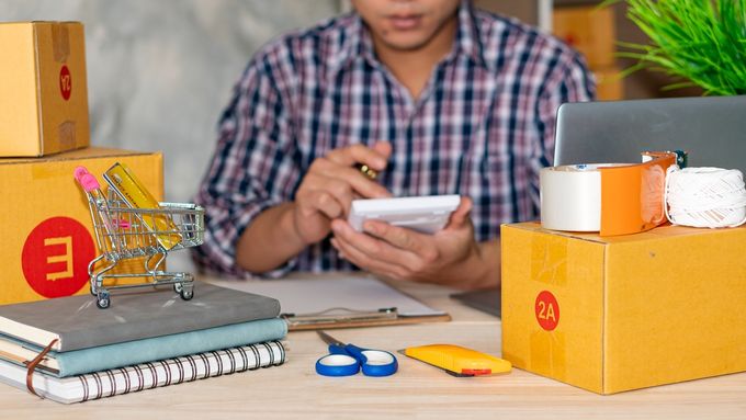 A man using a calculator checking his inventory